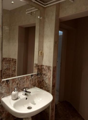 a bathroom with a white sink and a mirror at A-Piramida in Wrocław