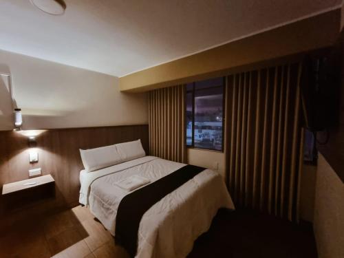 a hotel room with a bed and a window at Hotel Rey in Huancayo