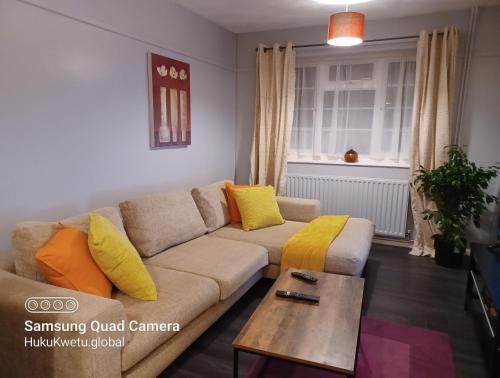 a living room with a couch and a table at Poynters House - Huku Kwetu Luton & Dunstable - Spacious 2 Bedroom House-Private garden and parking in Luton