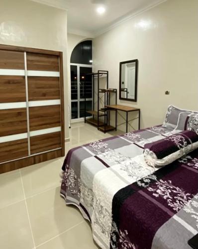 ein Schlafzimmer mit einem großen Bett und einem Spiegel in der Unterkunft Santai Homestay Kangar in Kangar