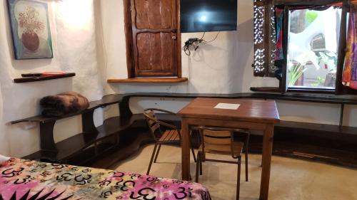 a room with a table and a bed and a table and chairs at La Quinta Orquídea in Puerto Morelos