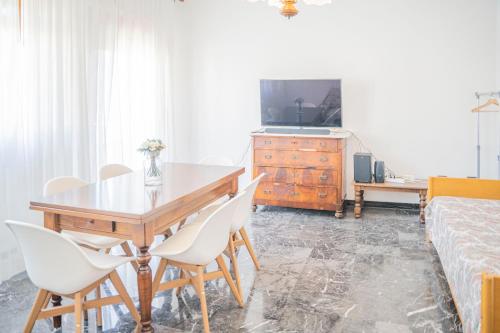 a dining room with a table and chairs and a bed at 083 - Casa Grande con Attico condominiale vista mare, 500 metri dalla spiaggia in Chiavari