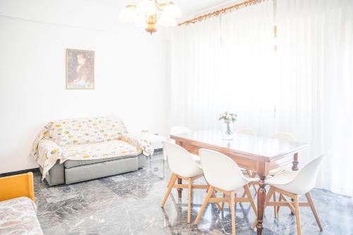 a dining room with a table and chairs and a bed at 083 - Casa Grande con Attico condominiale vista mare, 500 metri dalla spiaggia in Chiavari