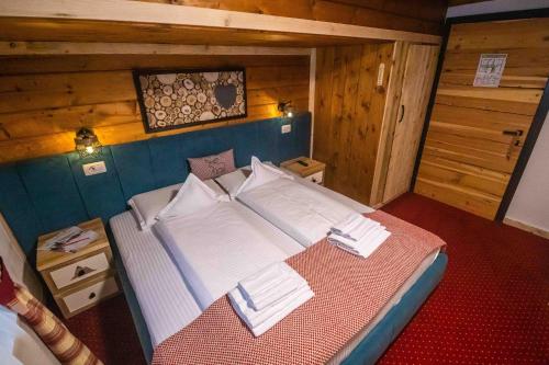 a large bed in a room with wooden walls at KITZALPEN Pension in Hollersbach im Pinzgau