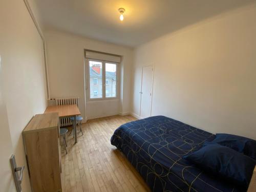 a bedroom with a bed and a desk and a window at Appartement T4 Cité Cardaillac, Parking Privé, Wifi in Rodez