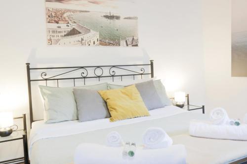 a bedroom with a white bed with yellow pillows at SANTA CROCE GUEST HOUSE in Venice