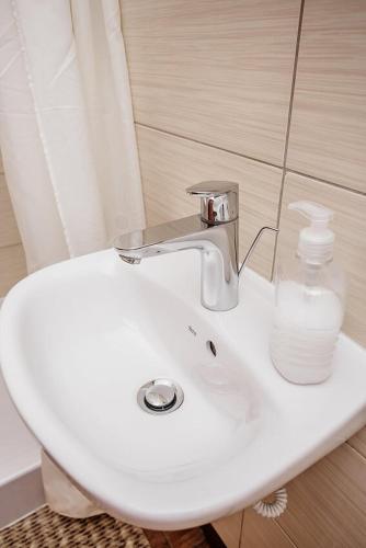 a white sink with a bottle of water on it at Guest House "Arkhistratyg" in Lviv