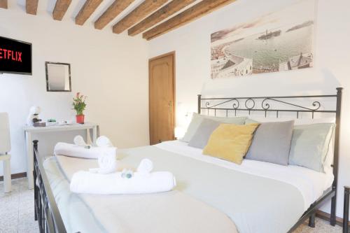 a bedroom with a white bed with towels on it at SANTA CROCE GUEST HOUSE in Venice