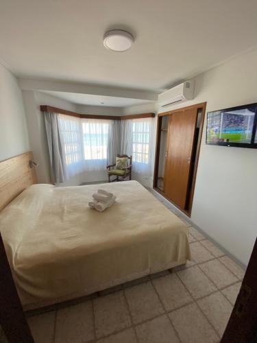 um quarto com uma cama grande num quarto em Gemelos Apart em Villa Gesell