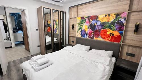 - une chambre avec un lit blanc et une peinture murale dans l'établissement Kule Apart, à Istanbul