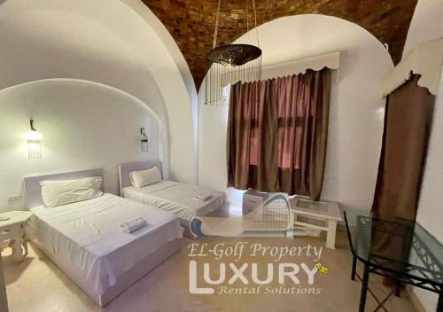 a small room with two beds and a window at Villa 4 Bed Rooms-North Golf-GN24 in Hurghada