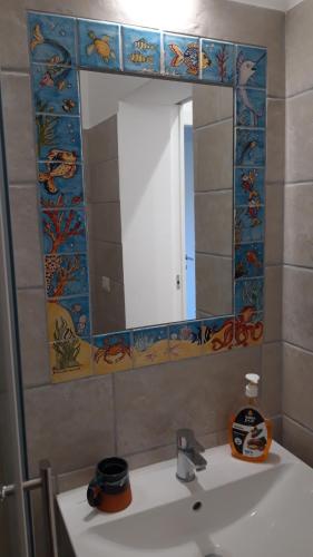 Un baño con un lavabo con un espejo grande. en Villa NinniTina, en Noto