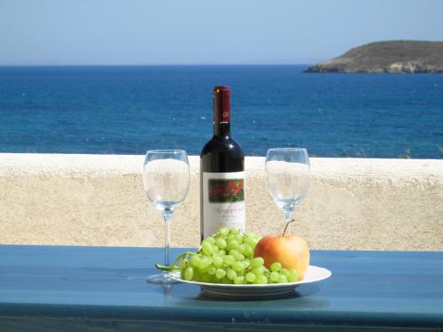 a plate of grapes and wine glasses on a table at Blue & Sea Studios Apartments in Drios