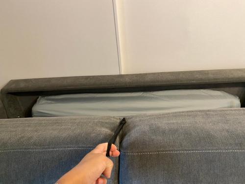 a person using a knife to cut into a couch at Le Bohème - Appartement proche gare et commerces in Gisors