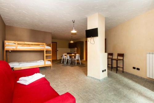 ein Wohnzimmer mit einem roten Sofa und einem Etagenbett in der Unterkunft Maison Sauze Centro in Sauze dʼOulx