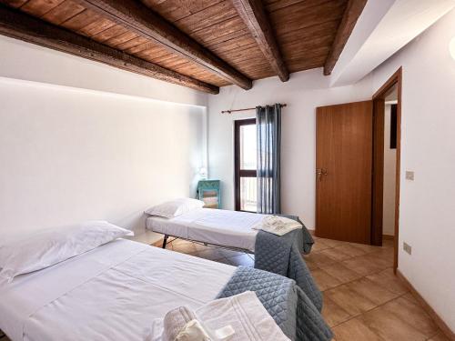 Una habitación de hospital con dos camas y una ventana. en Calauriia Apartments Marzamemi, en Marzamemi