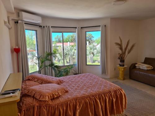a bedroom with a bed and two large windows at Precioso apartamento a 1km de la playa. in Barra del Chuy