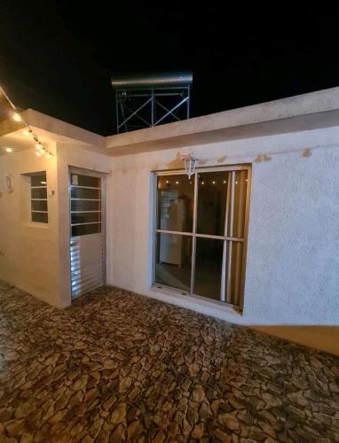 uma casa branca com uma grande janela do lado em Precioso apartamento a 1km de la playa. em Barra del Chuy