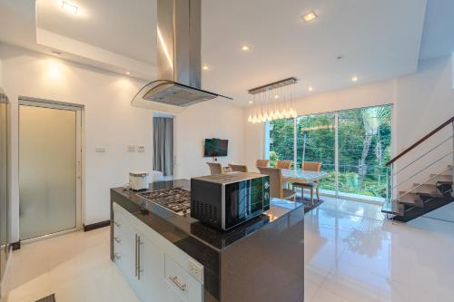 a kitchen with a counter top with a microwave at White Villa Patong in Patong Beach