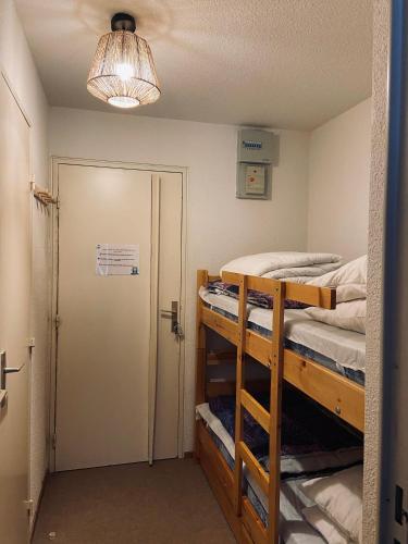 Cette chambre comprend 2 lits superposés et une porte. dans l'établissement Studio 4 personnes - accès direct remontées mécaniques, aux Contamines-Montjoie