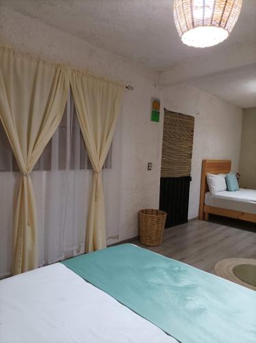 a bedroom with a bed and a bed and curtains at Alojamiento el nixtamal in Oaxaca City