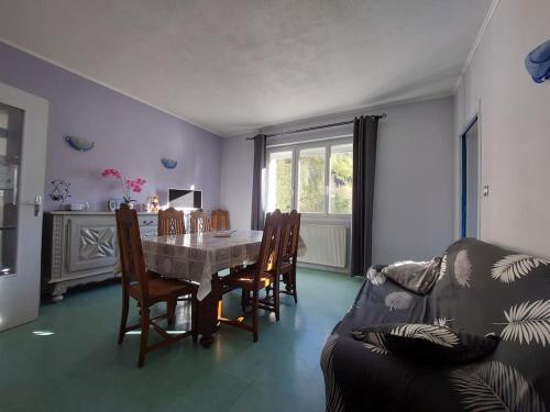 un salon avec une table, des chaises et un canapé dans l'établissement Beau jardin proche randonnée ski calme plain pied, à Auzat