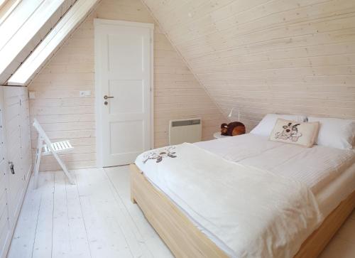 ein Schlafzimmer mit einem großen Bett im Dachgeschoss in der Unterkunft Domkiwturawie pl in Turawa