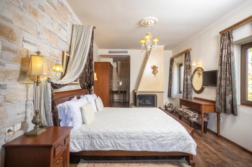 1 dormitorio con cama y pared de piedra en Alseides Boutique Hotel, en Elatochórion