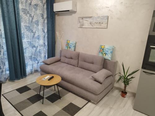 a living room with a couch and a table at Апартамент 3 А in Varna City