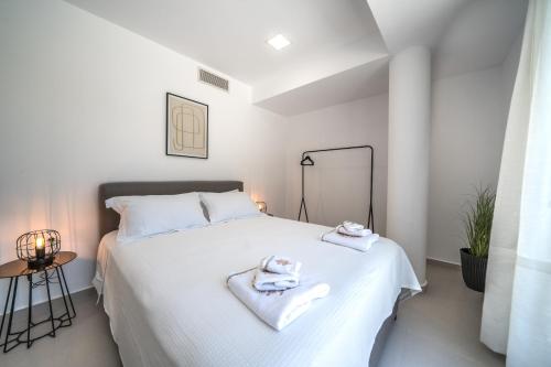 a bedroom with a white bed with towels on it at Villa Vivian Heated Private Swimming Pool & Jacuzzi in Georgioupolis