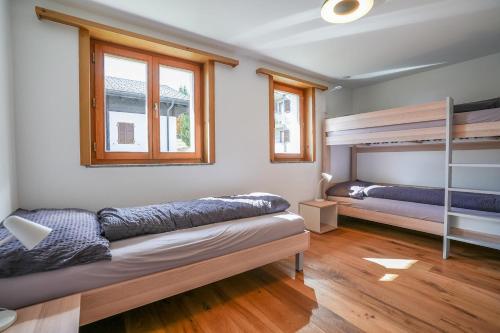 a bedroom with two bunk beds and wooden floors at Serenella Apartment in Riederalp