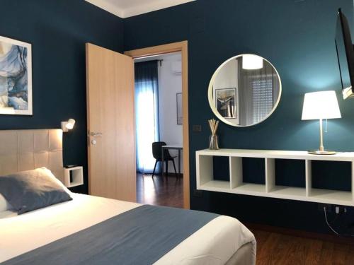 sypialnia z łóżkiem i lustrem na ścianie w obiekcie Blu Balena - appartamento piano attico con terrazze w mieście Tarent
