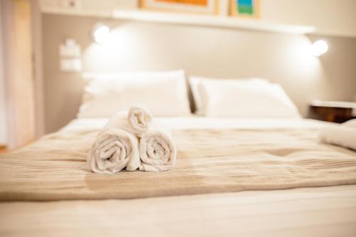 a bed with two rolled towels on it at Home Dren in Prepotto