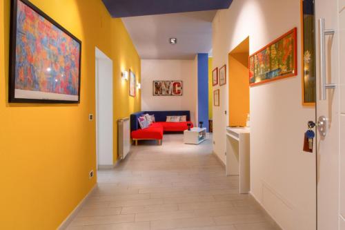 un pasillo con paredes amarillas y un sofá rojo en CIVICO 7 - Appartamento moderno e rifinito, en Ariccia