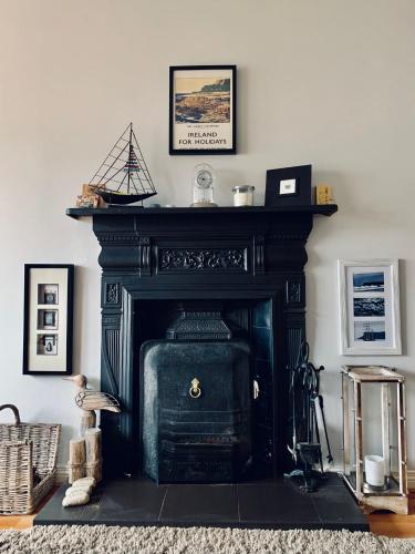 a black fireplace in a living room with aumed at Ballycastle Holiday Home in Ballycastle