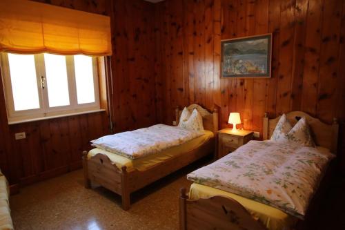トレメッツォにあるCasa Melina 1のベッドルーム1室(ベッド2台、窓付)