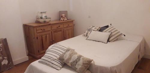 - une chambre avec un lit avec des oreillers et une armoire en bois dans l'établissement Appartement cosy au coeur du centre historique., à Arles