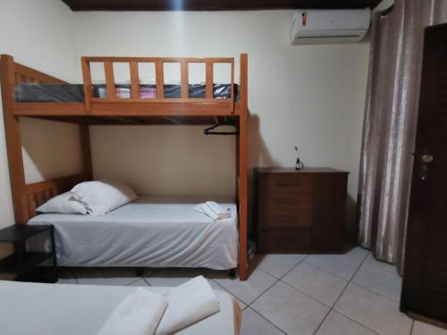 a bedroom with two bunk beds and a dresser at Sos Hostel in Camaçari