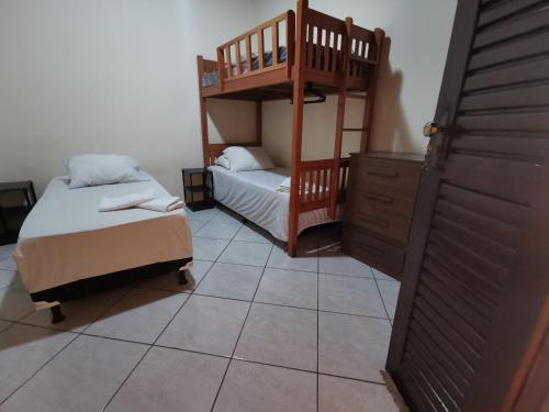 a bedroom with two bunk beds and a staircase at Sos Hostel in Camaçari