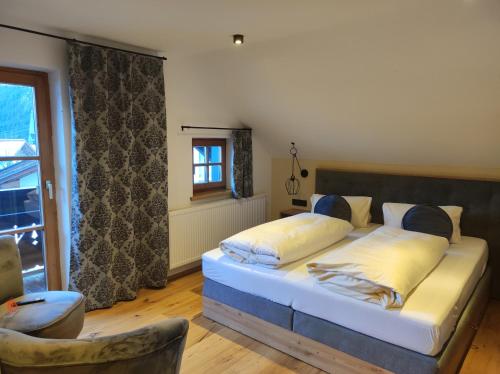 a bedroom with a bed and a chair and a window at Hotel - Landgasthof Post in Bichlbach