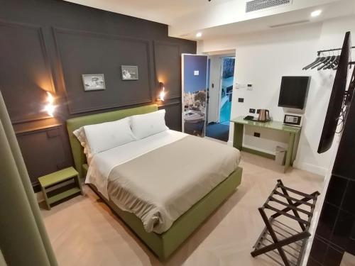 - une chambre avec un lit, un bureau et une télévision dans l'établissement Hotel XBusiness, à Nola