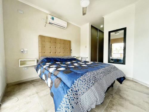 1 dormitorio con 1 cama con edredón azul y blanco en Don Francisco Apartamentos en Villa Carlos Paz
