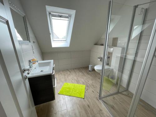 uma casa de banho com um chuveiro, um lavatório e um WC. em Backbord Greetsiel em Krummhörn