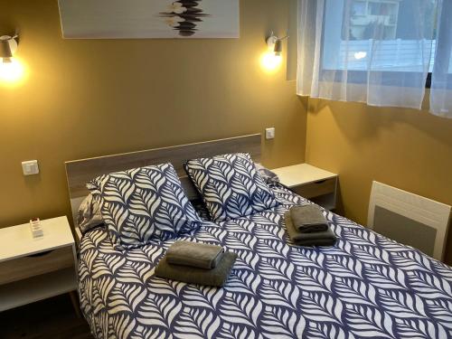 un lit avec deux sacs en dessus dans l'établissement Le Petit Fabre, à La Roche-sur-Yon