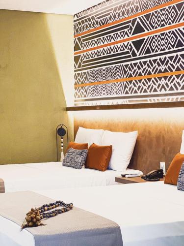 a bedroom with two beds and a wall with a mural at Wakanda Hotel in Andradina
