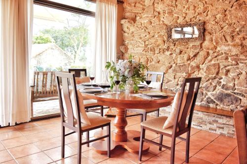 una sala da pranzo con tavolo e sedie in legno di Casa do Caseiro A Costa da Morte a Jornes