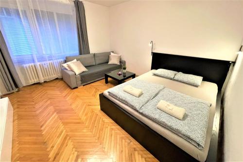 a living room with a bed and a couch at Apartment Helen - Old Town, AC in Bratislava