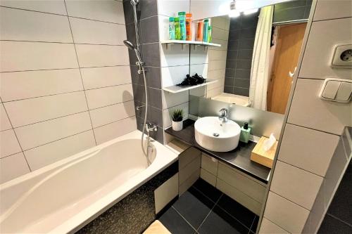 a bathroom with a tub and a sink at Apartment Helen - Old Town, AC in Bratislava