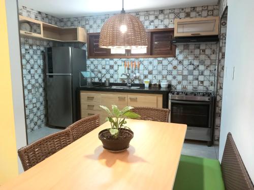 uma cozinha com uma mesa com um vaso de plantas em #residencialvillajeri - CASA térrea com VARANDA, máq de lavar, 300m da PRAIA em Jericoacoara