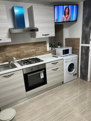 a kitchen with a stove and a washing machine at Petite Suite in Naples